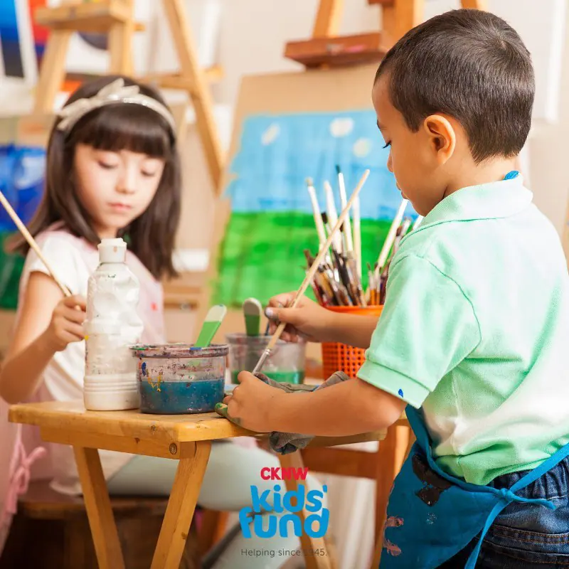 Two children painting at easels