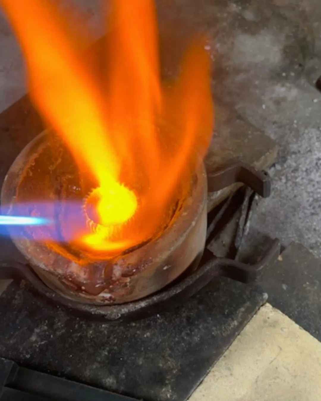 Gold from an heirloom ring melting under the torch in a crucible
